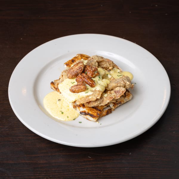 Rusty's Riverfront Grill's seafood dish with fried oysters, grilled fish, and creamy sauce.